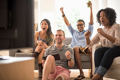 Friends celebrating something they are watching on the TV