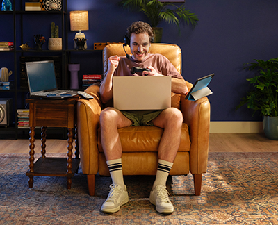 Bruce sitting in his chair, enjoying his internet on his laptop, tablet, and phone