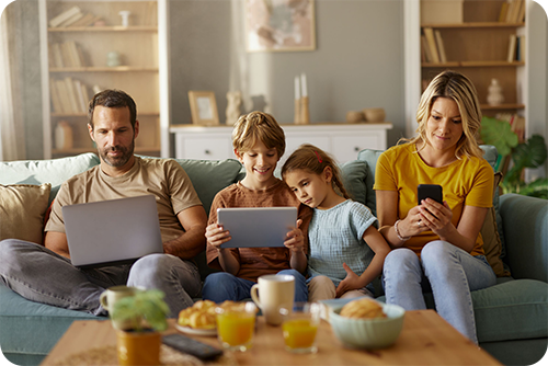 Family using Quantum Fiber on their laptops and AT&T Wireless on their mobile device